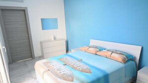 A bedroom with a bed, a nightstand, a drawer unit, and a door. - Villa Noire 'just 900mt From The Crystalline Waters Of Salento (Nardò)