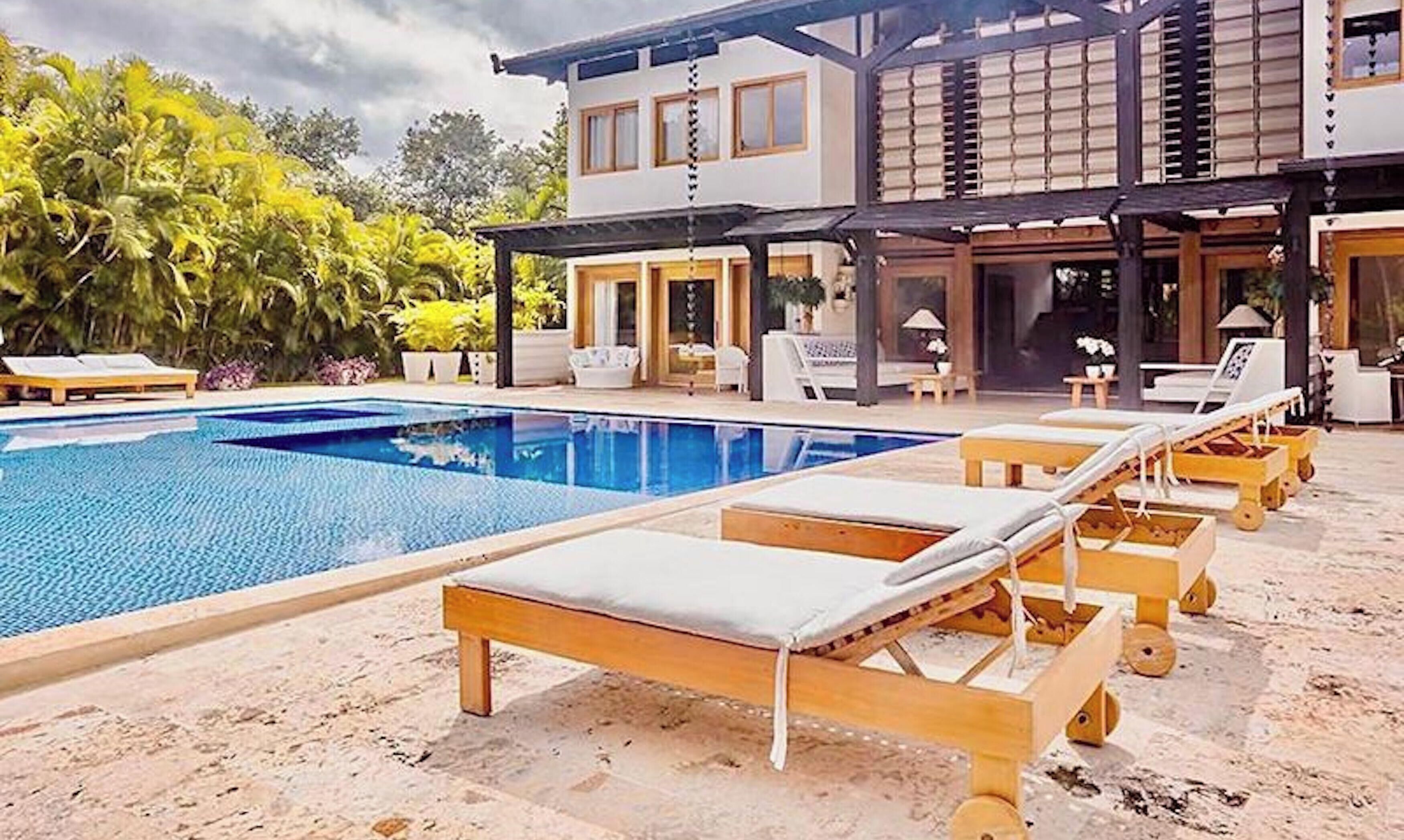 A modern pool area with lounge chairs and a covered patio.