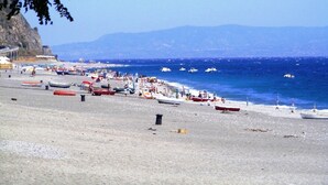 A beach with boats and people.