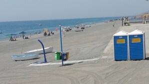 A beach with portable toilets, a boat, and a clear sky. - Villetta Singola a 20metri dal Mare per Soggiorni - Cure Termali Vicino Taormina (Ali Terme)