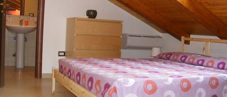 Un dormitorio con estructura de cama de madera, cómoda, mesita de noche y ventana con techo de madera.