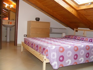 A bedroom with a wooden bed frame, a dresser, a bedside table, and a window with a wooden ceiling. - Villetta Singola a 20metri dal Mare per Soggiorni - Cure Termali Vicino Taormina (Ali Terme)