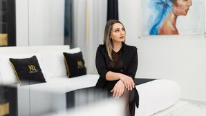 A person sitting on a white sofa with black cushions, in a room with a white wall and a painting. - Room in B&B - Queen Suite With Whirlpool tub - B&B Kreart Suite & Rooms (Crotone)