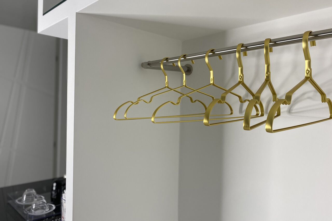 A metal rod with gold-colored hangers attached to it.