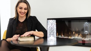 A woman sitting at a table with a book, a decorative vase, and a fireplace in the background. - Room in B&B - Queen Suite With Whirlpool tub - B&B Kreart Suite & Rooms (Crotone)