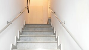A staircase with white railings and a light source at the top.