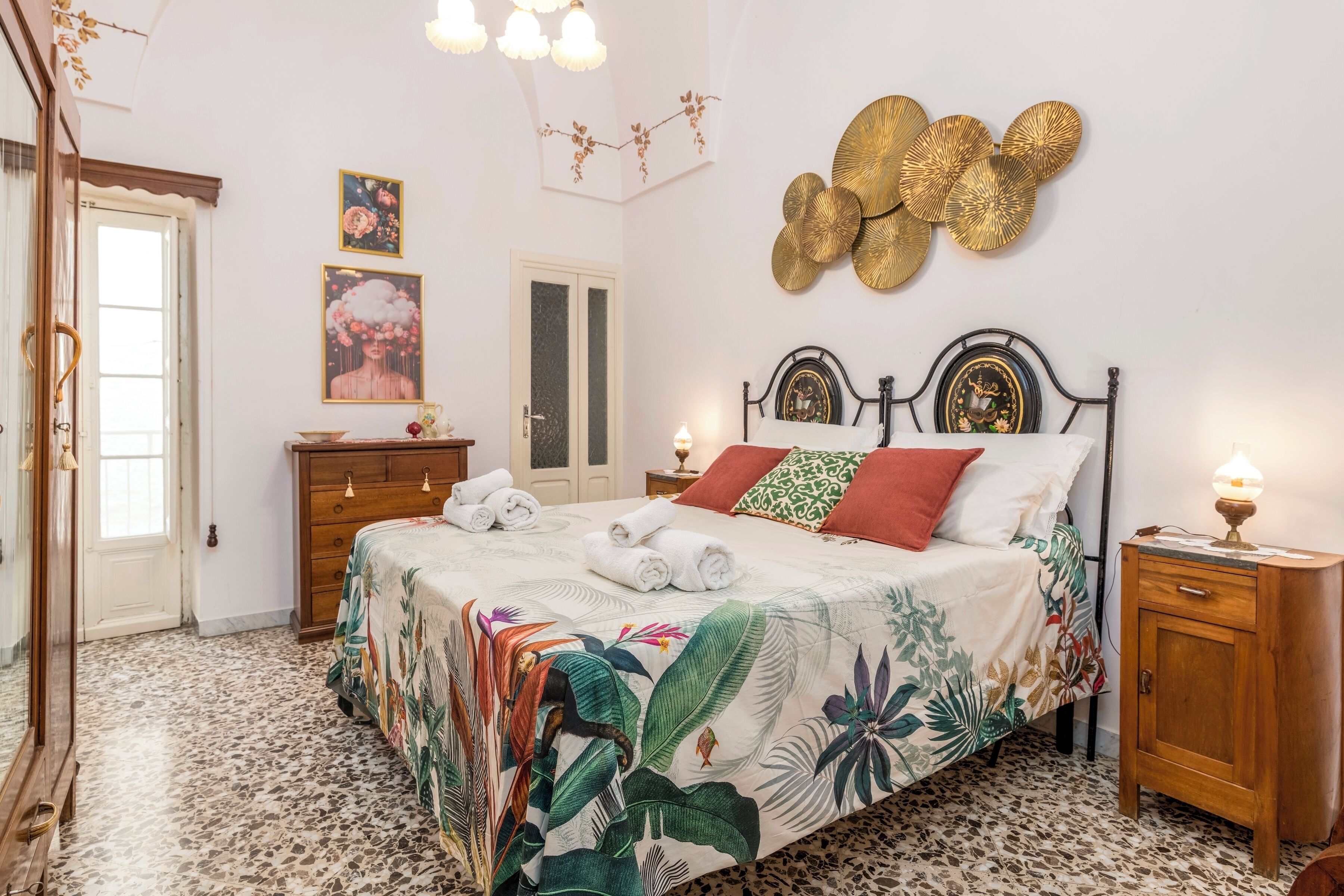 Ein Schlafzimmer mit einem Bett, einem Nachttisch, einer Holzkommode und einer Tür.