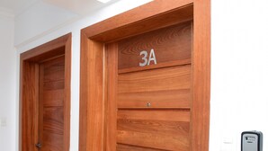 Two wooden doors with a number plate, a keypad lock, and a checkered mat at the entrance. - Apto En Zona Privilegiada De Santo Domingo City (Santo Domingo)