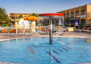 Une piscine dotée de chaises longues et agrémentée d’un élément décoratif aquatique.