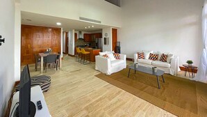 A spacious living area with a dining table, two sofas, and a kitchen in the background. - Srvittinivillas Aptla/p11 Great Apartment /work Travel / Couple /altos de Chavon (La Romana)