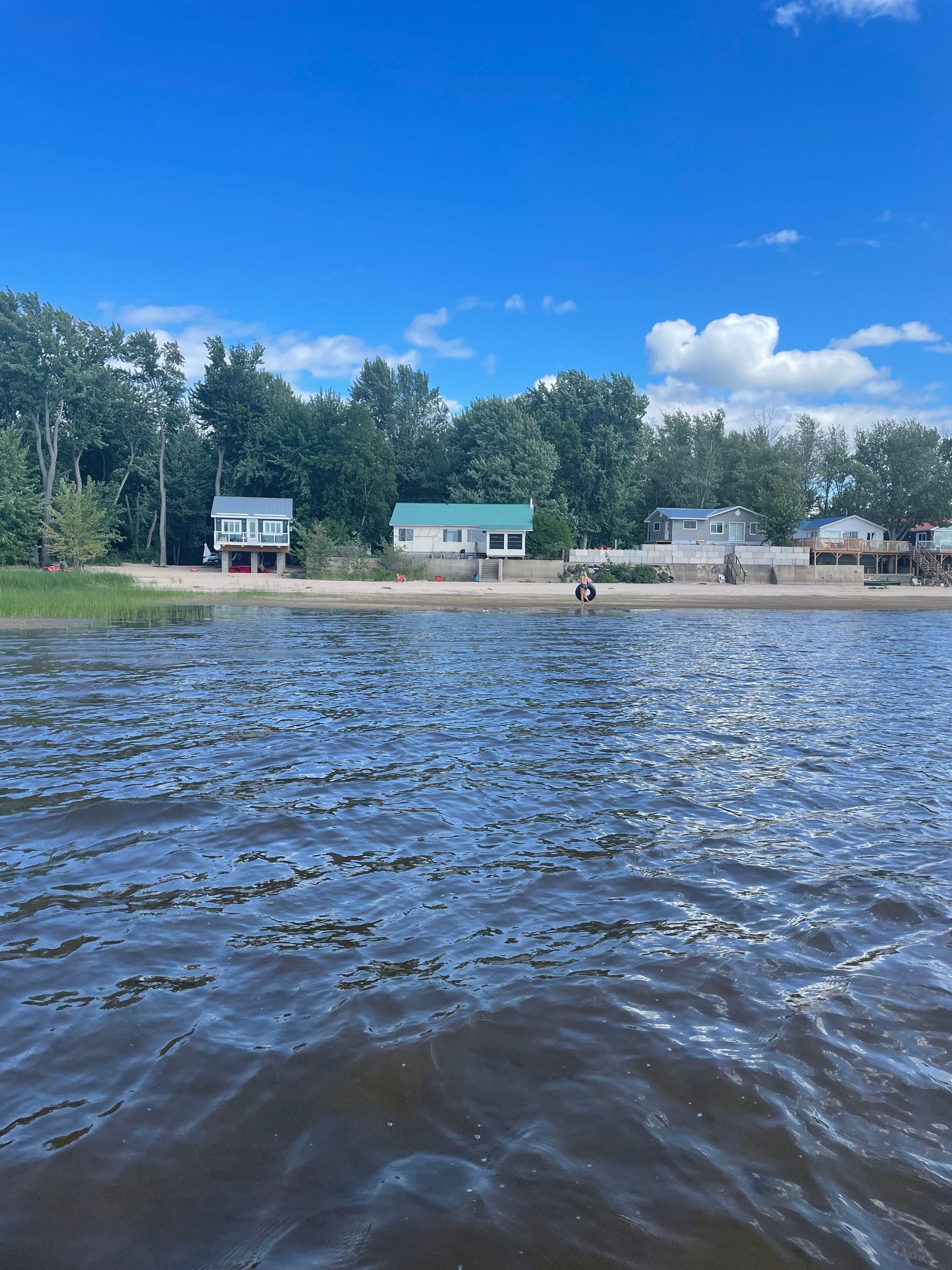A lakeside view with houses and a dock.
