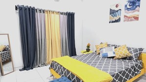 A bedroom with a bed, a bench, a mirror, curtains, and wall art. - Tuareg Place Aeropuerto A,C (Alajuela)