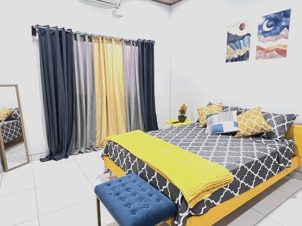 A bedroom with a bed, a bench, a mirror, curtains, and wall art. - Tuareg Place Aeropuerto A,C (Alajuela)
