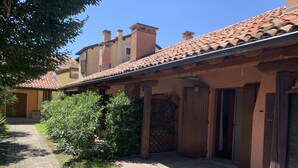 A courtyard with a tiled roof, a brick pathway, and a small garden area.
