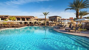 A swimming pool with lounge chairs and umbrellas, surrounded by buildings and palm trees. - Westin Desert Willow Villas, Palm Desert (Palm Desert)