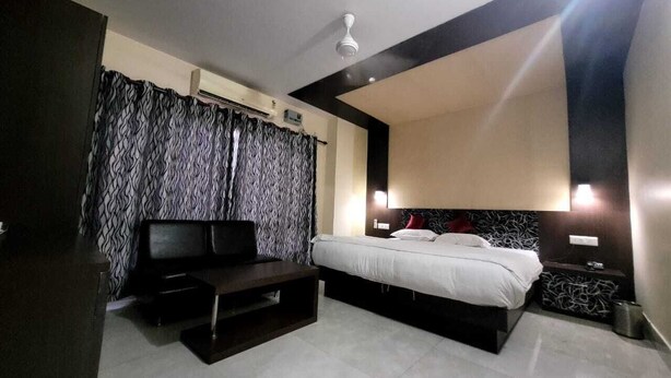 Quarto de hotel moderno com uma cama, uma escrivaninha e uma TV.