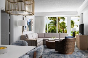 Relax in a spacious room with a comfortable seating area, dining table, and ocean views.