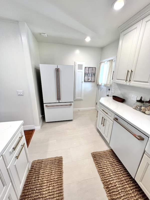 Kitchen features a double-door refrigerator, oven, and range hood above the stove.