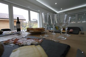 Ett matbord med en vinflaska, glas och en tallrik mat.