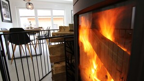 A modern living room with a fireplace, a dining area with a table and chairs, and a sofa. - Maison Cossue, Moderne et Calme à La Bresse 5 Chbr (La Bresse)