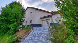 A building with a tiled entrance, surrounded by greenery and a clear sky. - Maison Cossue, Moderne et Calme à La Bresse 5 Chbr (La Bresse)
