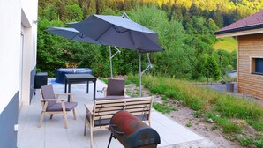 An outdoor patio with a table and chairs, a barbecue grill, and a large umbrella. - Maison Cossue, Moderne et Calme à La Bresse 5 Chbr (La Bresse)