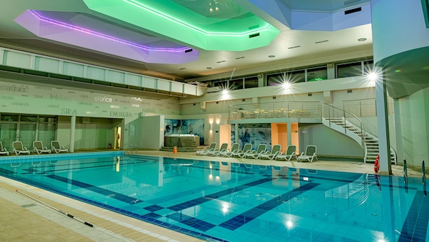 An indoor swimming pool with multiple levels, clear water, and a modern design with geometric ceiling lights. - Citi Hotel's Warszawa-Falenty (Raszyn)