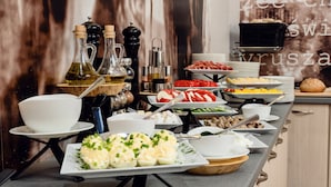 A buffet setup with various food items and condiments. - Citi Hotel's Warszawa-Falenty (Raszyn)