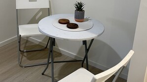 Une petite table ronde sur laquelle sont posés un pot de plante et deux sous-verres en bois.