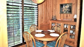 A wooden dining room with a round table, chairs, and a window with blinds. - 3 Bdrm in Georgetown's Historic District (Georgetown)