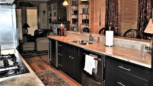 A modern kitchen with dark cabinetry, a granite countertop, and pendant lighting. - 3 Bdrm in Georgetown's Historic District (Georgetown)