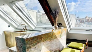 A modern kitchen with a marble countertop, a built-in sink, and a view of the city through large windows. - Duplex With Terrasse and vue on the Eiffel Tower (Paris)