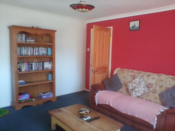 A living room with a bookshelf, a sofa, and a coffee table.