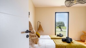 Un dormitorio con una cama, una ventana y vistas al exterior.