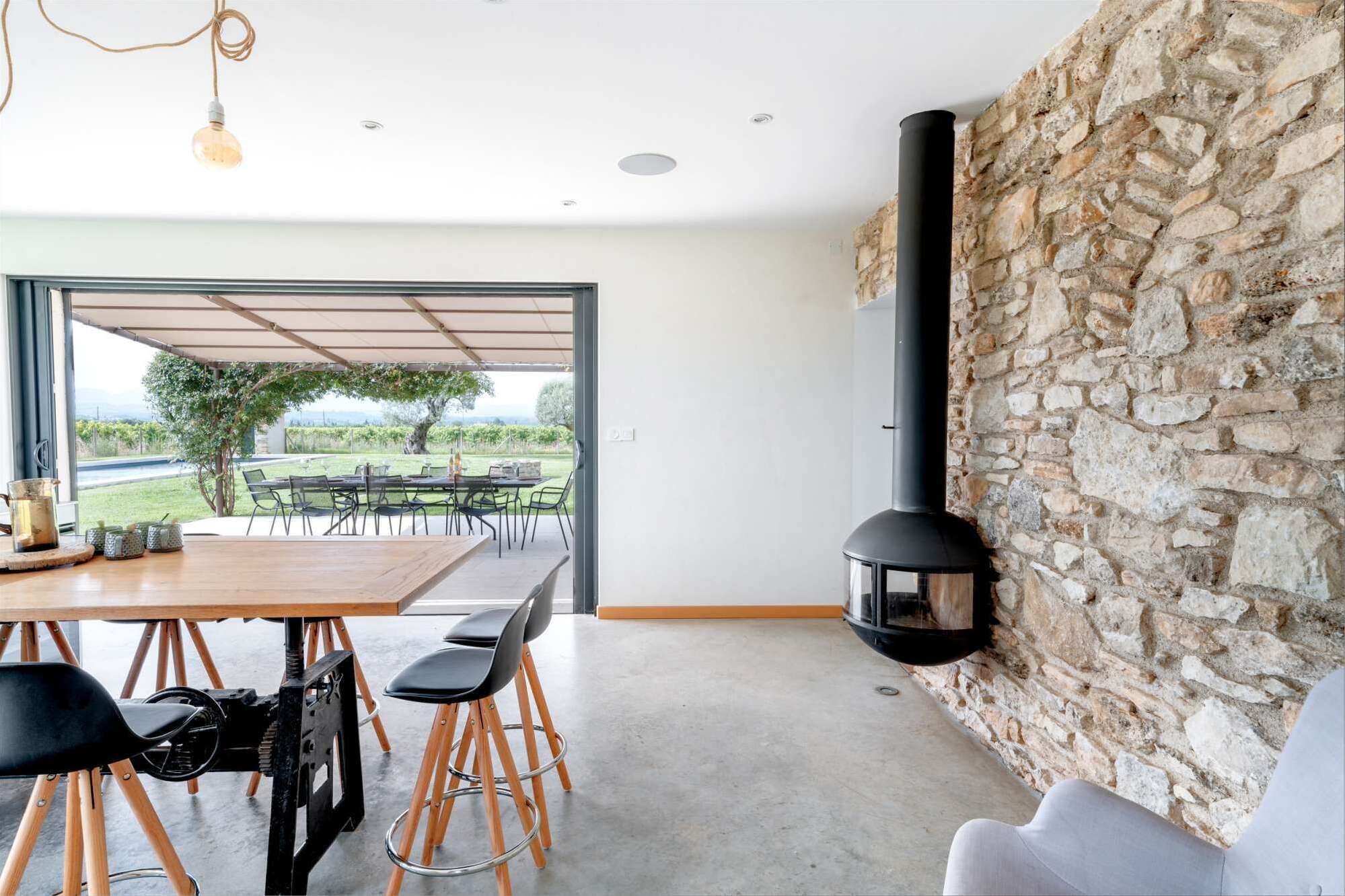 Un comedor moderno con una pared de piedra, una mesa grande y sillas.