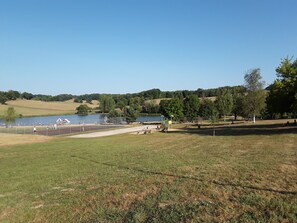 Ein Park mit einem Spielplatz, einem See und Bäumen.