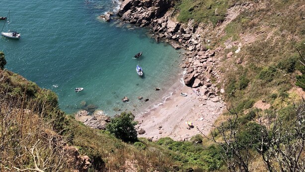 A coastal landscape with clear blue waters, rocky shores, and a hilly backdrop. - Stunning views, period town house, central Dartmouth close to river, quiet road. (Dartmouth)