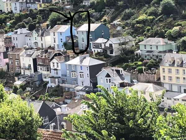 Um bairro residencial com casas de várias cores e estilos arquitetônicos, rodeado por vegetação.