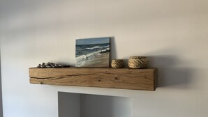A wooden shelf with a painting of a seascape, two woven baskets, and a pile of stones. - Stunning views, period town house, central Dartmouth close to river, quiet road. (Dartmouth)