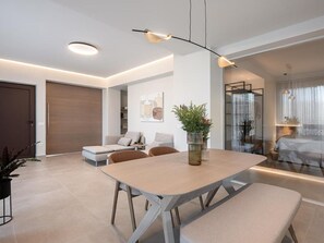 En moderne stue med spiseplads, med et stort bord, sofaer og en glasvæg.