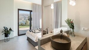 A modern bedroom with a large bed, a round sink, and a view of a lake through a sliding door.