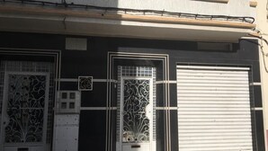 A building facade with two decorative metal doors and a garage door. - Belgium district (Tanger)