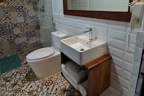 Habitación Deluxe | Baño | Regadera, regadera tipo lluvia, pantuflas, toallas