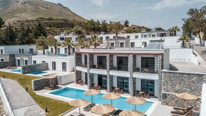 A modern resort with multiple buildings, a swimming pool, and outdoor seating areas.