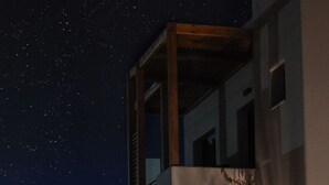 Una pared de piedra con un letrero que dice "NORTH WIND Luxury Suites - OIA - Santorini".