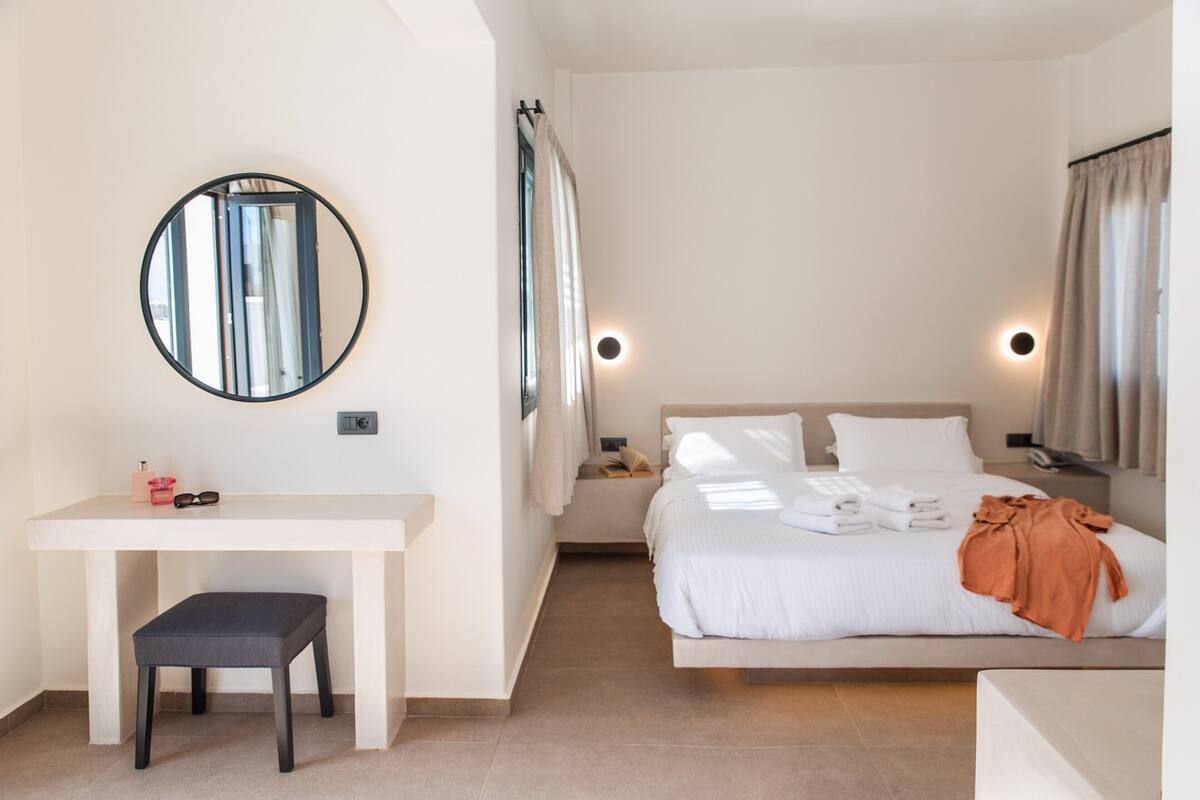 Ein Schlafzimmer mit einem Bett, einem Nachttisch und einem Schreibtisch mit Stuhl.