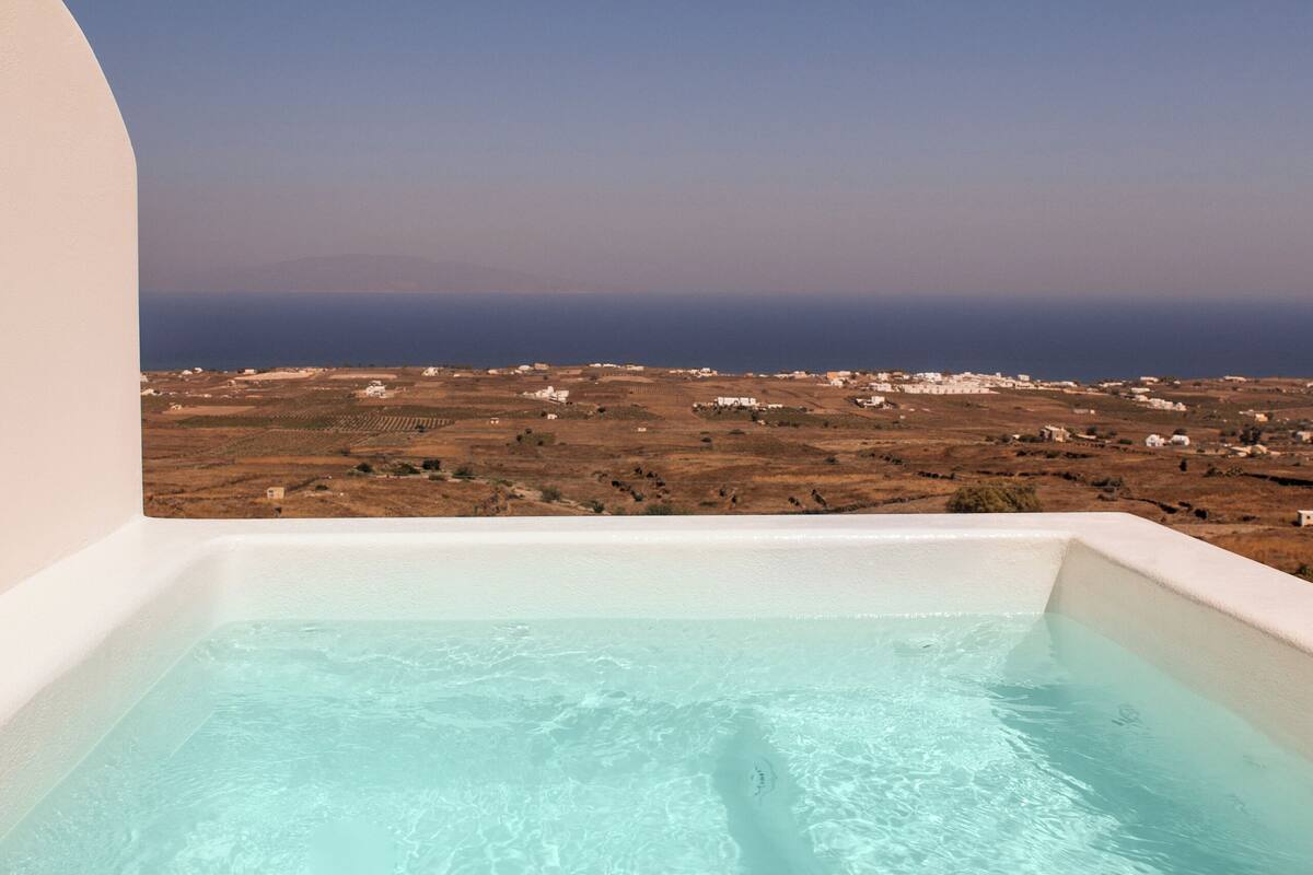 Ein klarer Blick auf einen Pool mit weißem Innenraum und einer schönen Landschaft im Hintergrund.