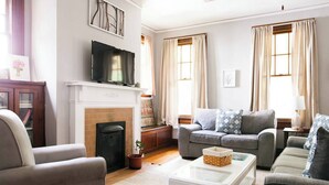 A living room with a fireplace, a television, and a sofa set. - Bring everyone. Spread out, settle in, and make Montgomery feel a little more like home. (Montgomery)