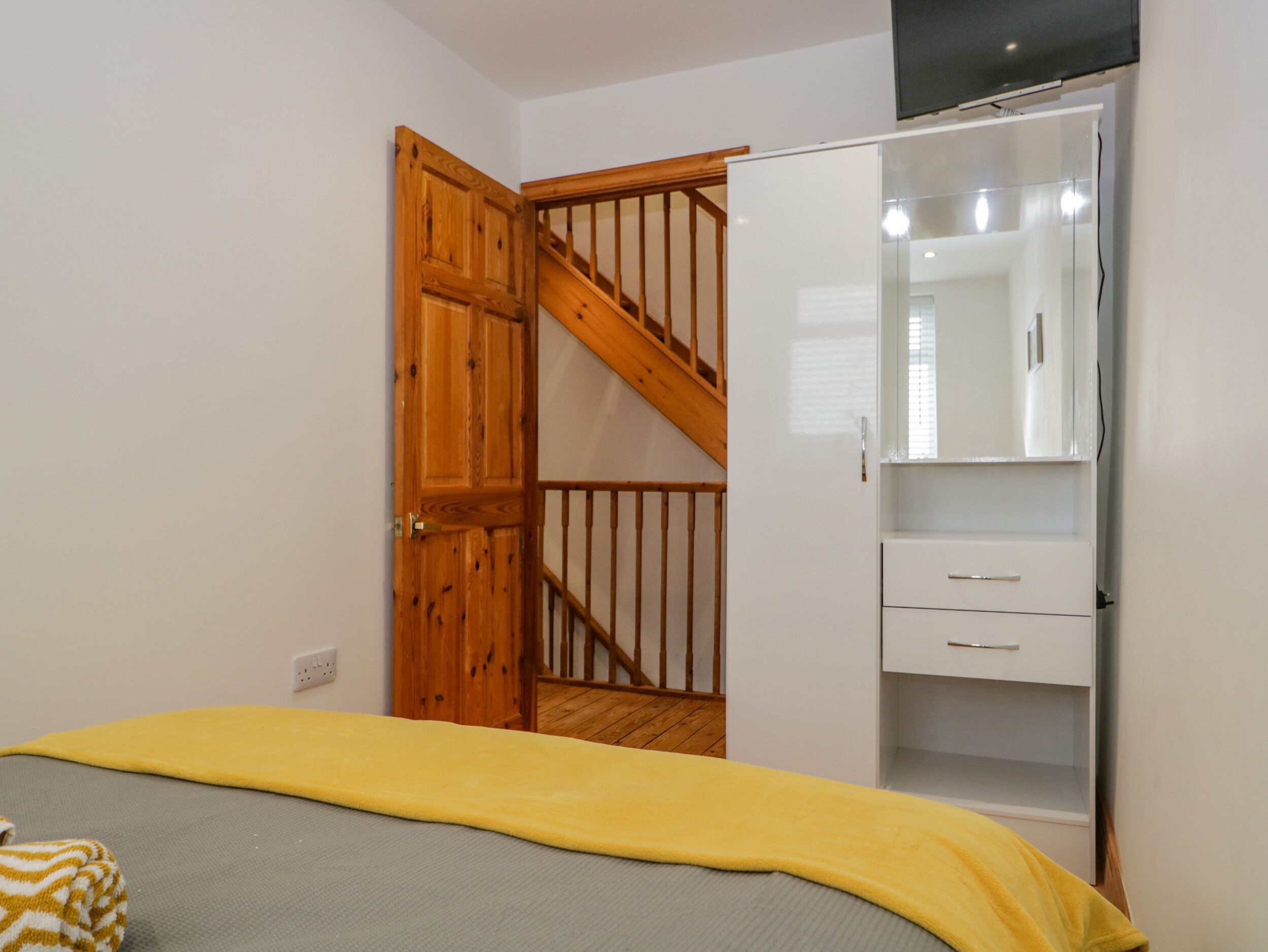 Une chambre à coucher avec un lit, une armoire et un escalier.