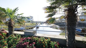 Un canal bordé de bateaux, de palmiers et de fleurs aux couleurs vives.